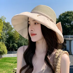 Elegant Hepburn style straw sun hat with large organza bow for summer beach vacation