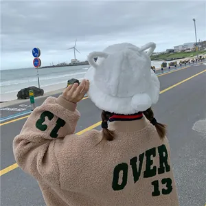 Close-up back view of a cute white plush bucket hat with animal ears and a pom-pom tail