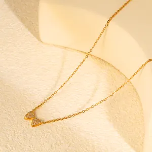 Primer plano detallado de un collar con colgante de lazo dorado y circonitas