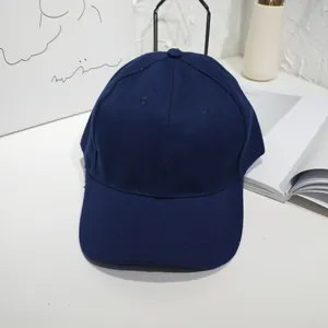Classic navy blue cotton baseball cap with curved brim on white minimalist desk