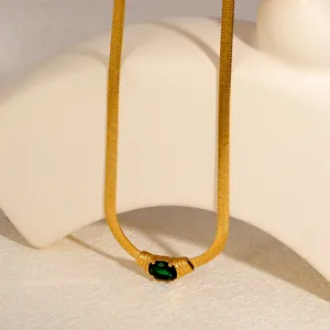 Detail shot of a vintage gold herringbone necklace with an oval emerald green zirconia