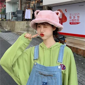 Close-up of pink plush bucket hat with cute bear ears on an Asian model.