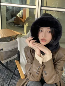 Stylish black plush winter hood with ear protection shown on a model outdoors