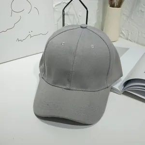 A detailed view of a plain grey solid color baseball cap in a minimalist lifestyle setting