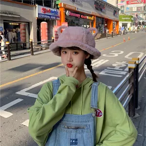 Sweet pink plush bucket hat with cute ears shown in a trendy street lifestyle setting