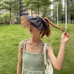 Nahaufnahme eines modischen Damen-Sonnenvisiers mit breiter Krempe in einem Außenpark
