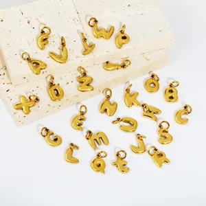 Detailed macro shot of 3D puffy 18K gold plated stainless steel alphabet charms on stone