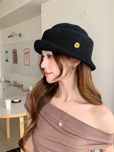 Close-up of a stylish black French Hepburn-style rolled-brim hat worn by a model