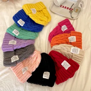 Una vivace composizione piatta di berretti in maglia a trecce in vari colori pastello