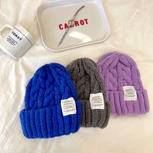 Tre berretti in maglia a trecce in blu grigio e viola per calore e stile invernale