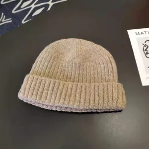 Close-up macro view of the soft ribbed knit texture on a classic beige docker beanie skull cap