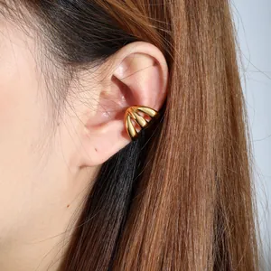 Close-up view of a gold-plated stainless steel multi-band ear cuff on a female model's ear