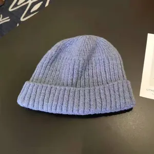 Close-up detail of a soft blue men's winter warm knitted beanie hat with ribbed texture