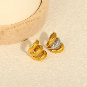 Close-up of multi-layer C-shaped stainless steel ear cuffs in gold and silver finish