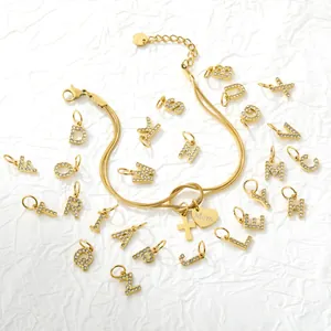 Vista dettagliata di 26 ciondoli con lettere in strass dorati e collana snake chain
