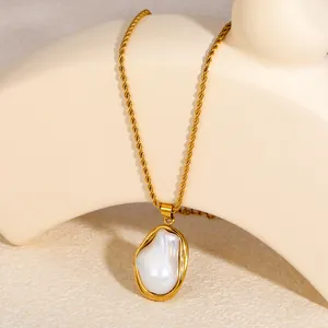 Nahaufnahme eines eleganten Anhängers mit unregelmäßiger Perle an einer vergoldeten Kette