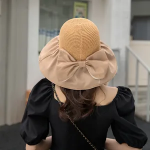 Rear view of a stylish summer sun hat featuring a large fabric bow and straw crown detail