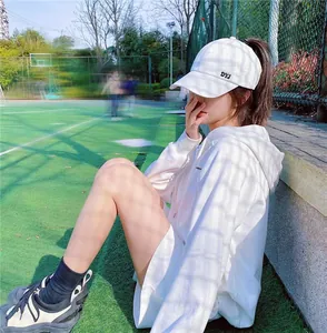 Vue latérale d'une casquette de baseball blanche pour femme sur un terrain de sport ensoleillé
