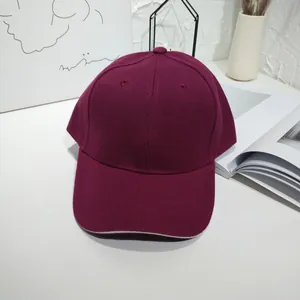 Close-up view of a minimalist burgundy twill baseball cap with a white sandwich brim