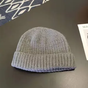 Close-up of a premium grey knitted beanie featuring soft ribbed texture and a classic folded brim