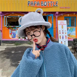 Close-up detail of a cute grey fuzzy bucket hat with bear ears on a female model