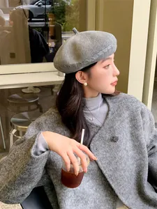 Close-up of a stylish gray knitted beret on a model, featuring delicate cable knit details.