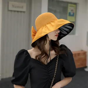 Elegant yellow wide brim sun hat with bow and black vinyl lining for sun protection