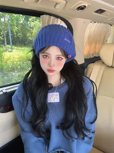 Stylish blue knitted wool headband beanie for warm winter outfit worn by female model