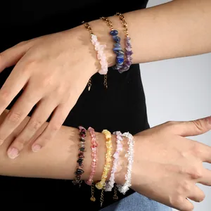 Vue détaillée de bracelets en éclats de cristal naturel avec chaînes en acier doré sur bras