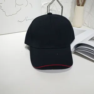Detail view of a classic black baseball cap featuring a stylish red trim on the curved brim