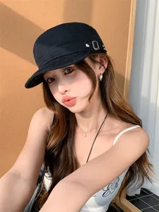 Casquette plate rétro noire avec rivets argentés portée par un mannequin asiatique