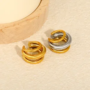 Detailed macro view of layered gold and silver stainless steel C-shaped ear cuffs