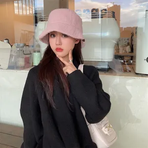 Stylish pink plush bucket hat for winter worn by an Asian model in a trendy cafe setting