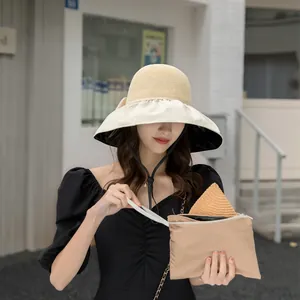Detailed view of women's wide brim sun hat with bow and matching storage pouch
