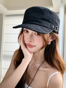 Gros plan d'une casquette plate vintage noire avec rivets portée par un mannequin.