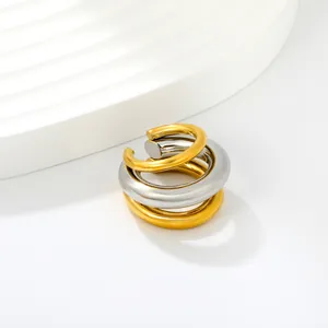 Close-up of a minimalist gold and silver two-tone stainless steel C-shaped ear cuff