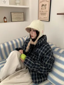 Lifestyle view of a warm plush trapper hat with ear flaps for women.