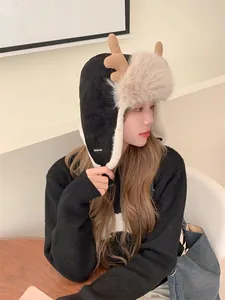 Close-up of a women's black winter Ushanka hat with plush reindeer antlers and fur trim