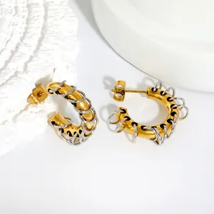 Detailed close-up view of bicolor C-shaped hoop earrings with silver coil wrap design