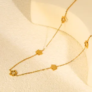 Detail shot of a minimalist gold-plated stainless steel necklace with maple leaf charms
