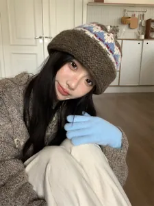 Detail of vintage ethnic style knitted wool bucket hat on model in cozy home setting