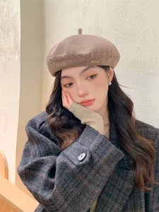 Close-up of a stylish brown knitted beret hat worn by a model in a cozy outfit.