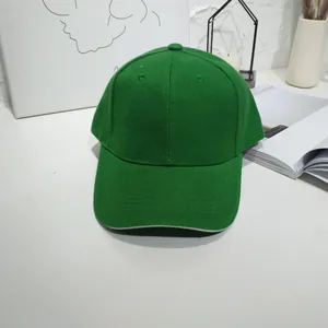 Classic green baseball cap shown from front view on a minimalist white table surface