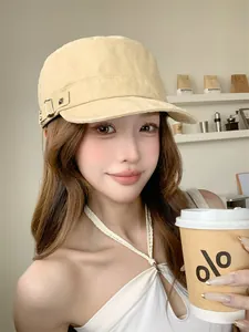 Une femme portant une casquette de cadet jaune vintage avec rivets dans un café
