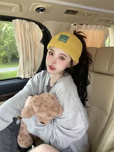 Close-up of stylish yellow knit wide headband worn by model in lifestyle car setting