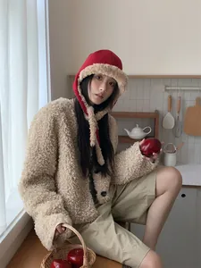 Korean style red winter ear protection hat with plush lining shown in a cozy kitchen setting