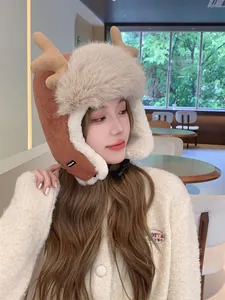 Plush winter trapper hat with deer antlers worn by a female model in a cozy cafe