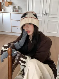 Woman wearing a vintage ethnic-style knitted bucket hat in a warm and cozy home kitchen.