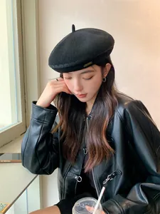 Stylish black breathable knitted beret hat for women shown on a model in a casual setting