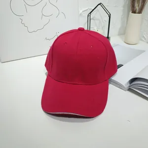 Close-up of a vibrant red unisex baseball cap with a white edge detail on the brim